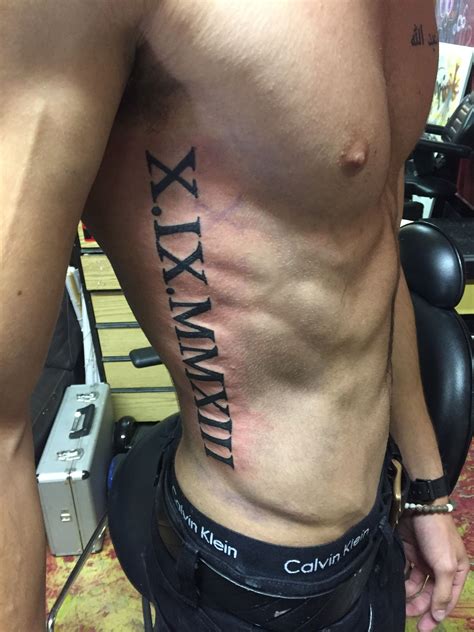 roman numerals rib tattoo|roman numeral tattoo on arm.